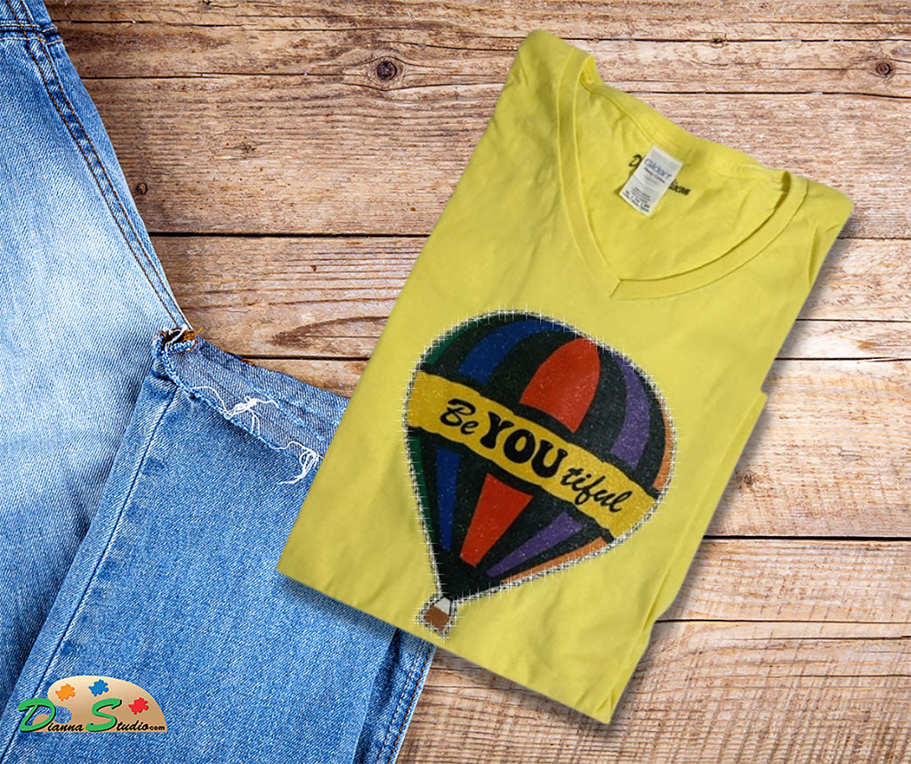 Air Balloon with BeYOutiful in the center on a yellow v neck shirt 