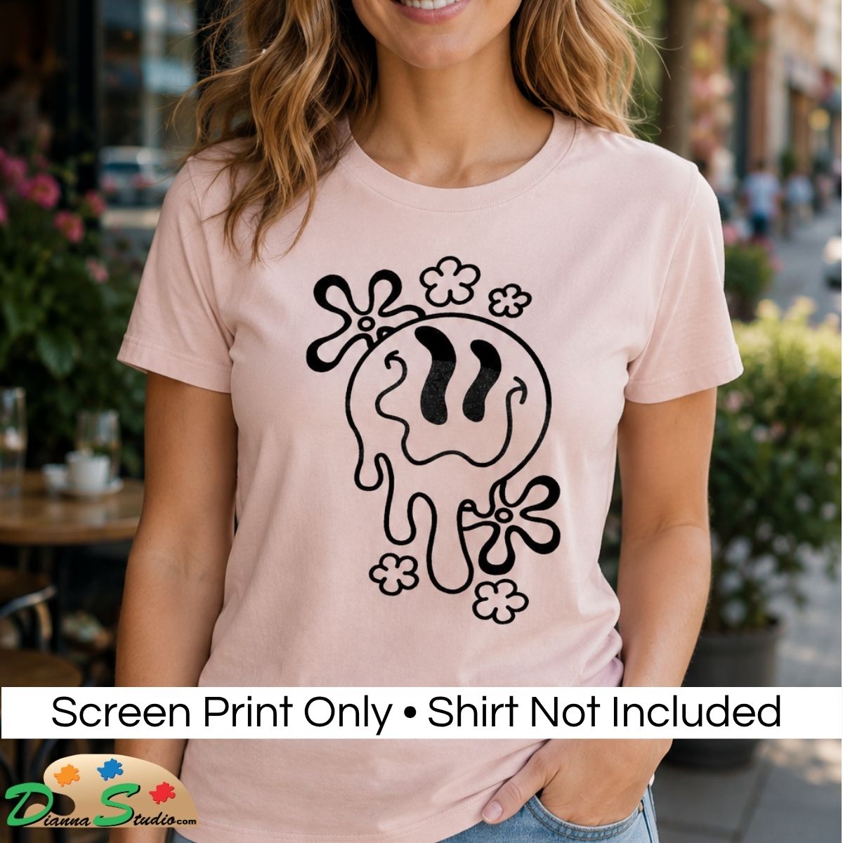 A woman wearing a light pink t-shirt with a black dripping smiley face graphic, set against a blurred outdoor cafe background. A white banner at the bottom reads 'Screen Print Only • Shirt Not Included'.