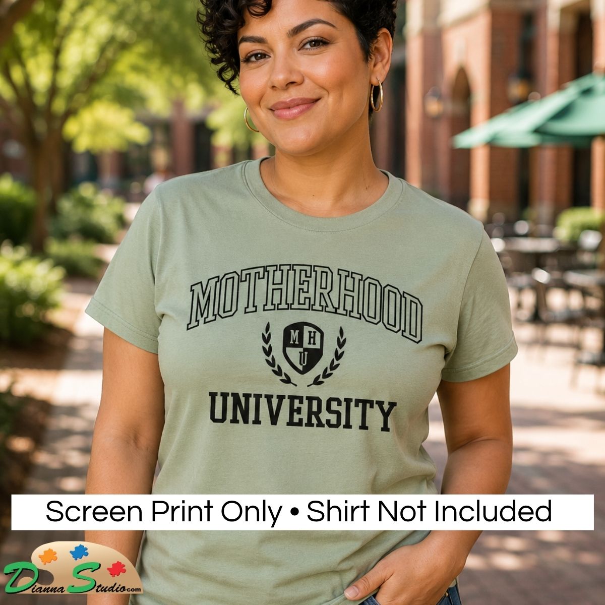 Screen Print Design “Motherhood University” and Crest logo in black. A happy woman wearing an Olive Green short sleeve crewneck tee. 