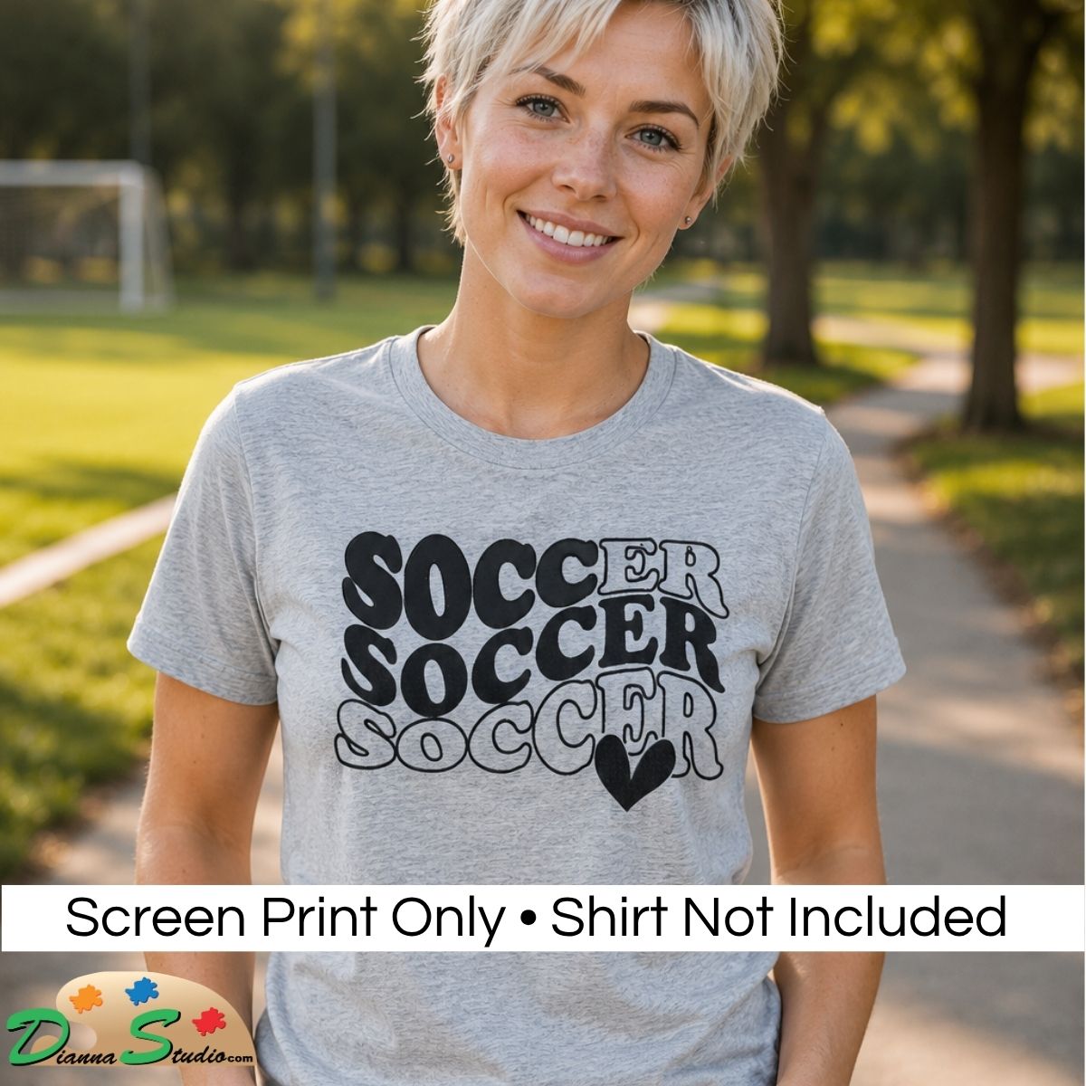 A woman outdoors wearing a heather gray t-shirt with a black and white graphic that reads 'SOCCER SOCCER SOCCER' with a heart. A white banner at the bottom says 'Screen Print Only • Shirt Not Included' and shows the 'DiannaStudios' logo.