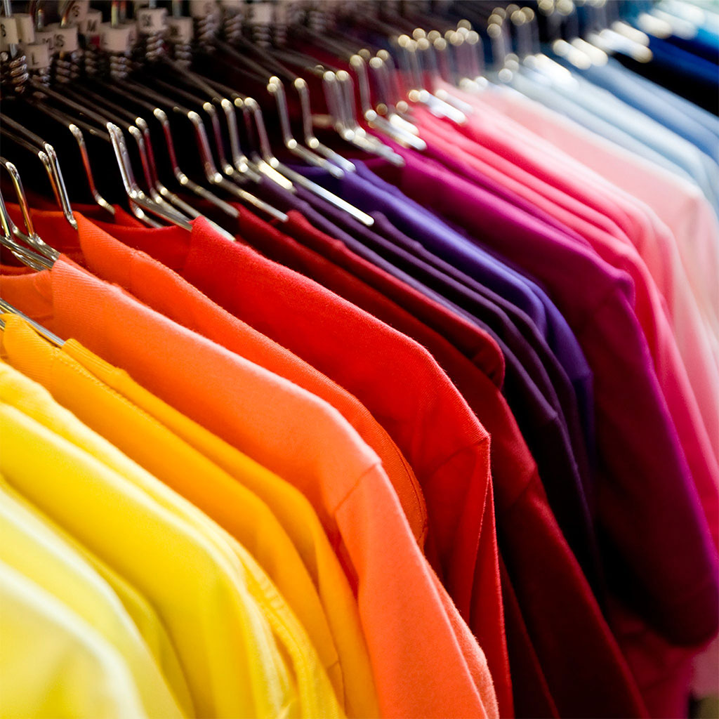 Colorful T-shirts displayed on hangers, showcasing a variety of apparel color options.