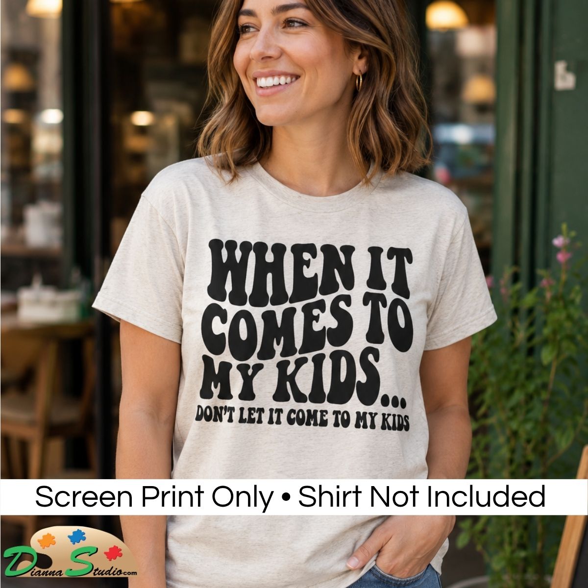 A woman wearing a light beige graphic t-shirt with bold black text that reads 'WHEN IT COMES TO MY KIDS… Don’t Let It Be About My Kids.