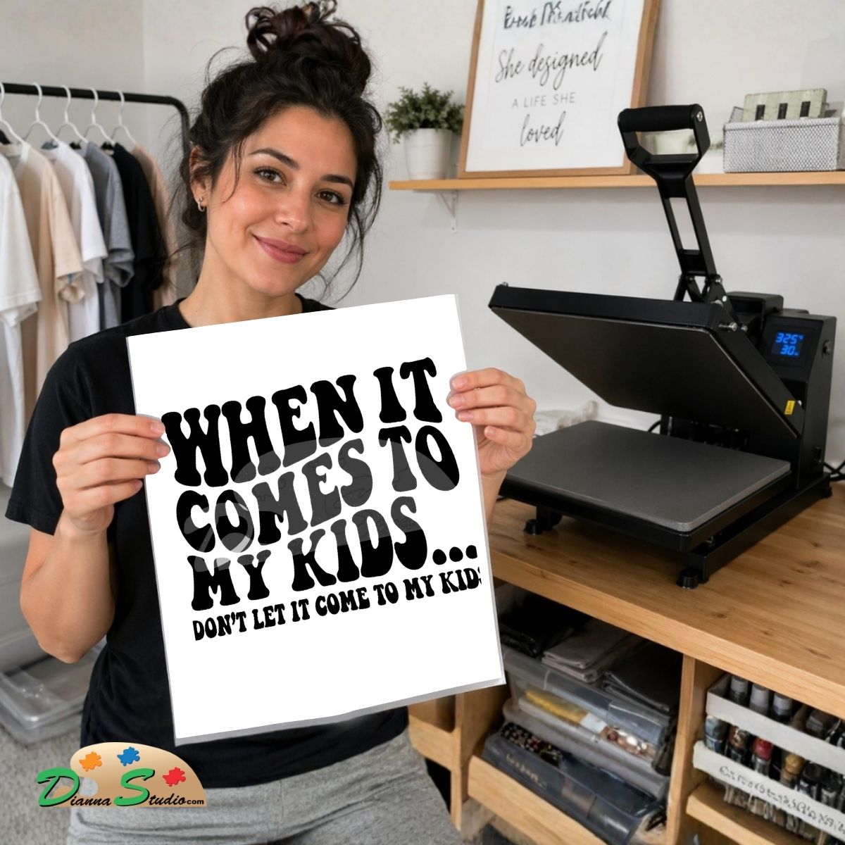 A woman holds up a white square print with bold black text reading 'WHEN IT COMES TO MY KIDS. Standing next  heat press.