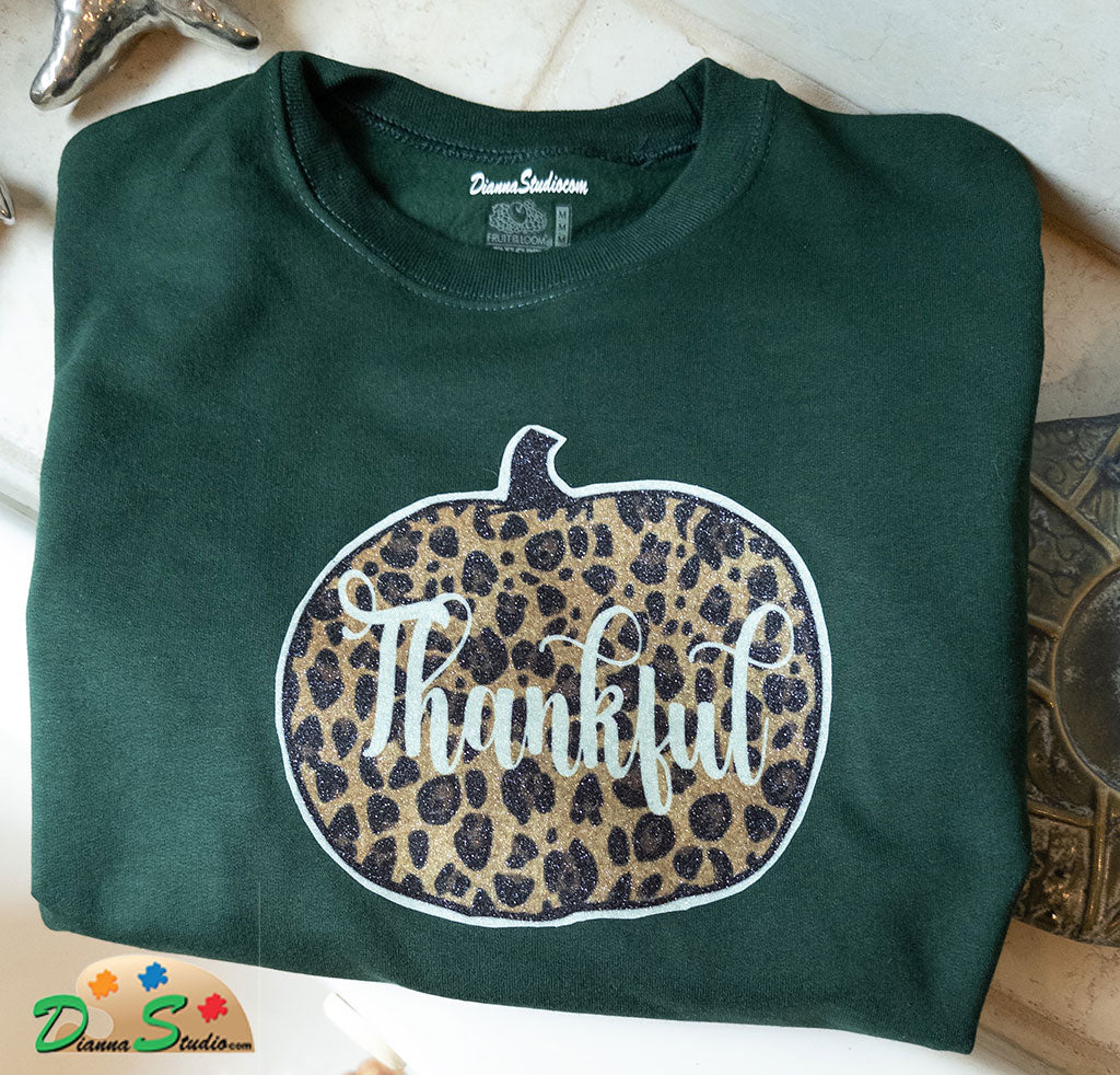 cheetah print pumpkin with Thankful, made out of glitter vinyl on a winter green sweatshirt