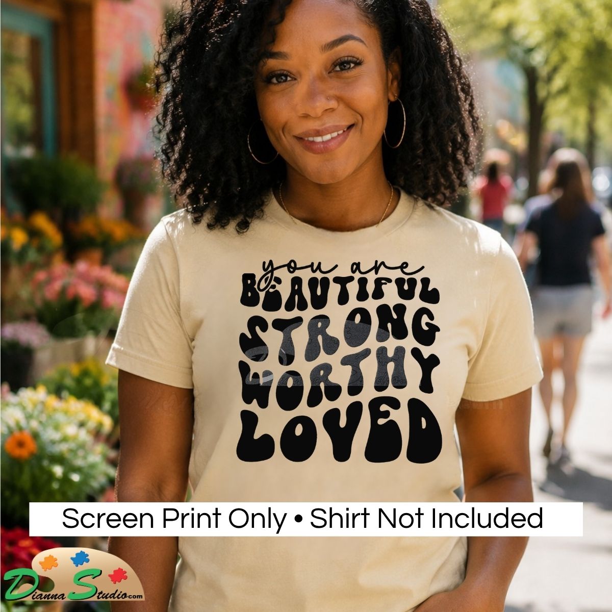 A woman outdoors wearing a cream-colored graphic t-shirt with the text 'you are BEAUTIFUL STRONG WORTHY LOVED' in black. A white banner at the bottom reads 'Screen Print Only • Shirt Not Included'.